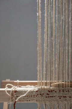 Loom mid weave where hand spun wool and fine steel thread cross into one cloth