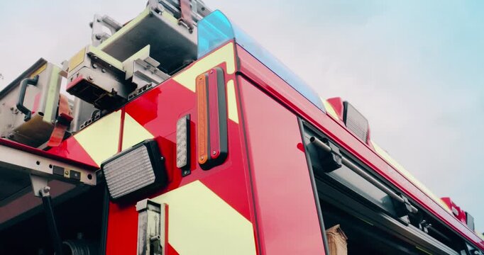 Fire truck emergency service vehicle with flashing lights. Red fire engine with ladders, firefighting apparatus and water to save lives, extinguish fires and assist vehicle collision.