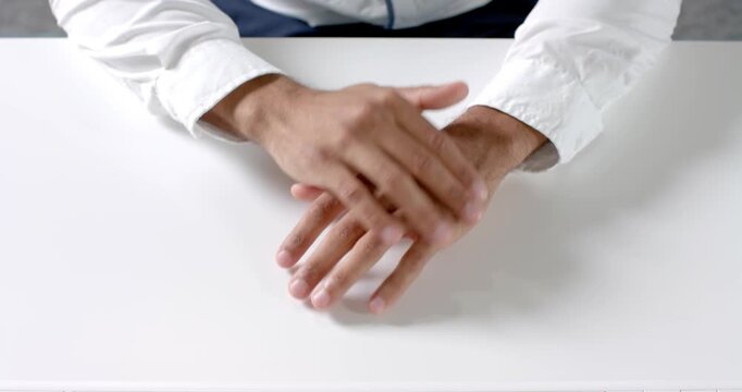 Close up of people talking to the camera, businessman sitting at desk, wearing white shirt, in offic