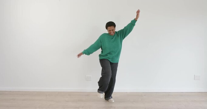 High-speed photography for dynamic scenes, dancing joyfully, woman in green sweater enjoying her tim