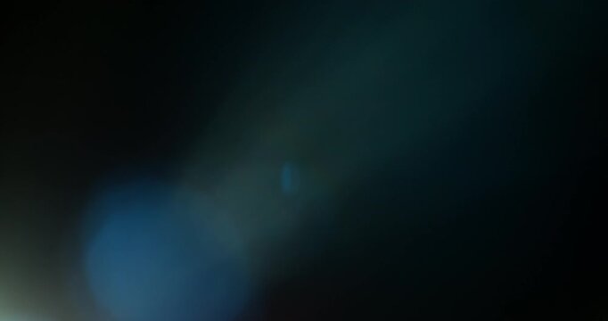 Slow motion of lens flare isolated on black background. Anamorphic lens. Cinematic glowing light overlay with optical streaks and rays for VFX compositing and transitions.
