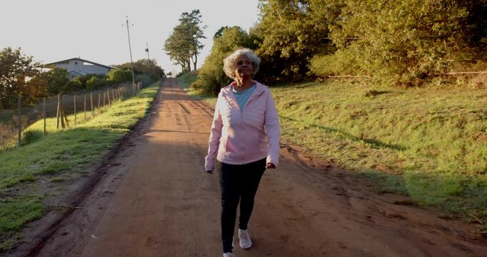 Lifestyle videos outdoor of people doing activities, walking on dirt path, woman enjoying morning ex