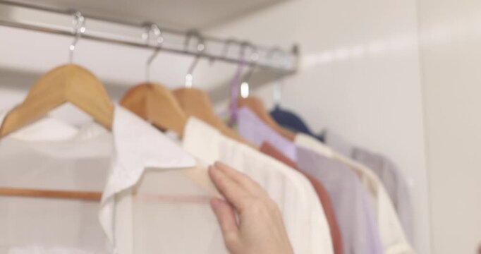Clothing items hanging on a rack with wooden hangers, apparel display.
