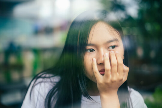 anxious worried teen girl with her smartphone as a conceptual backdrop for cyberbullying social media trauma, teenager mental health crisis, depression and panic attack