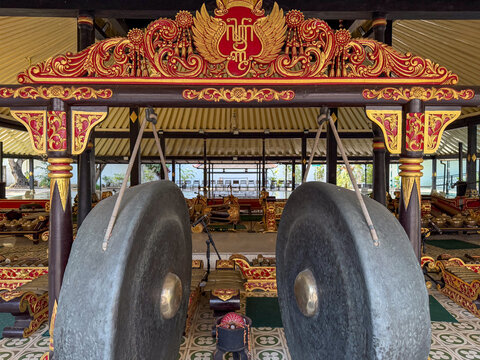 Large traditional gamelan gongs inside ornate Yogyakarta Sultan Palace pavilion