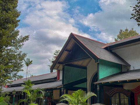 Javanese palace roof and pavilion architecture beneath blue cloudy sky