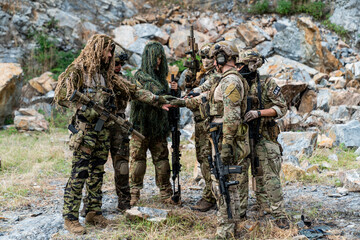 Fototapeta premium Soldiers prepare for an operation during training in a rocky outdoor area