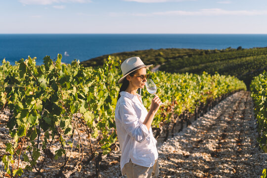 Woman tasting wine in coastal vineyard
