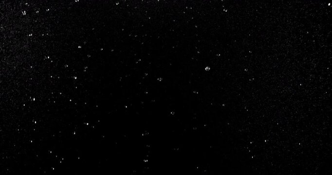 Slow motion floating water droplets on a black background. Premium VFX overlay for cinematic compositing, motion graphics, title animations, trailers and professional visual effects.
