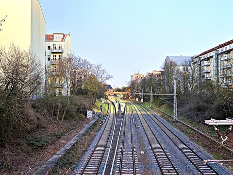 Train tracks curving through urban landscape with apartment buildings