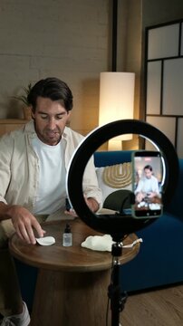Handsome man recording a social media video about men's grooming and cosmetic products