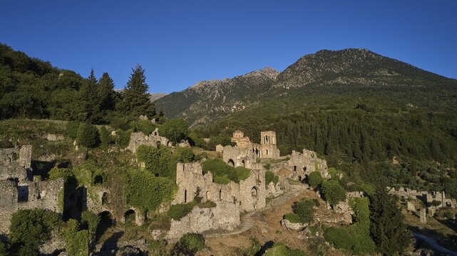 Drone shot, Historical ruins in a hilly landscape with a clear blue sky, Church of Agia Sophia from the 14th century AD, Mystras, Mistra, UNESCO World Heritage Site, Medieval Byzantine ruined city, northwest of Sparta, foothills of the Tyagetos Mountains, Peloponnese, peninsula, Greece