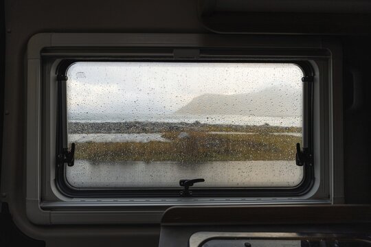 View from rainy campervan kitchen window on Flakstad beach, Flakstad, Lofoten, Norway