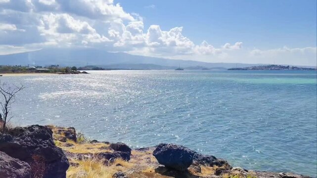 Calming sea waves. Surface and texture of pristine blue turquoise sea water during a hot summer day. Sand, beach, shore, costline