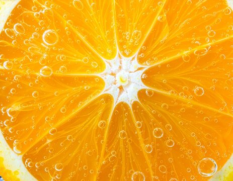 Saftige Orangenscheibe mit perlenden Wasserblasen