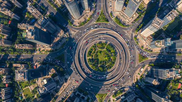 Aerial drone view of a busy urban roundabout with heavy traffic flow in a modern metropolitan city