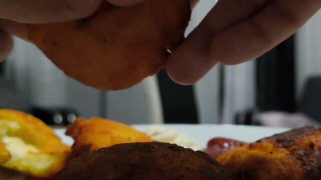 Close-up of hands breaking hot crispy fried pastry with melting stretchy cheese in slow motion