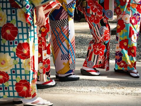 Woman wearing colorful traditional Japanese Kimonos with vibrant floral and geometric patterns