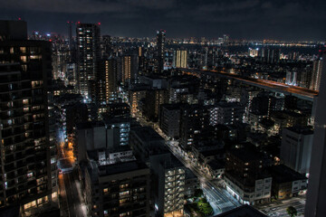 Obraz premium Tokyo Cityscape at Night with Illuminated Buildings and Urban Lights