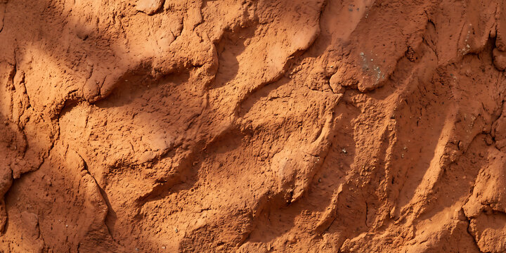 Cracked clay earth texture showing rough dry mud surface with deep furrows for natural backgrounds and rustic design elements.