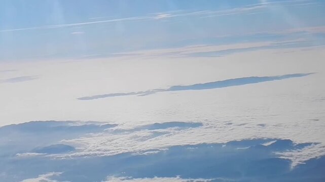 Morning cloudy aerial view with sun rays, texture of Stratocumulus low level clouds above land with Apennine Mountains in couds and mist and horizon with sunny blue sky. Topics: Apennines, air travel