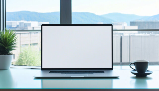 The image shows a laptop computer sitting on a glass desk in front of a large window. the laptop is open and has a blank white screen. on the desk the