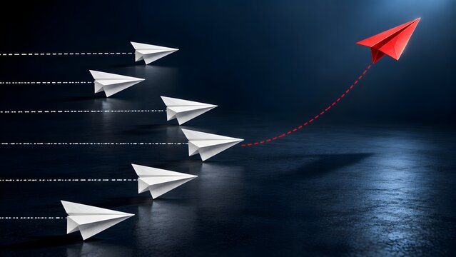 A red paper plane soaring upwards and breaking away from a fleet of white planes, symbolizing leadership, innovation, business success, individuality, and a unique strategic direction.