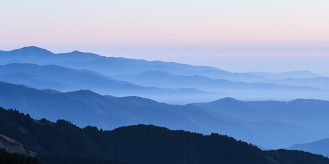Fototapeta premium Blue mountain ridges layered with pink sunrise sky