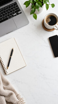 Minimal workspace flat lay with laptop, notebook, smartphone, coffee and green plant with copy space