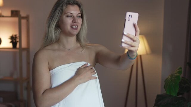 Selfie photo of woman in bedsheet. Internet webcam model streamer.