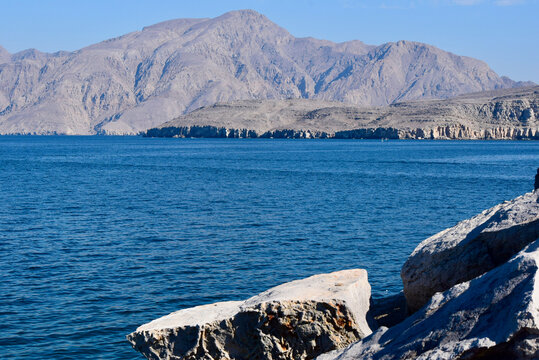 Desert Fjord in Musandam, Oman with Foreground Rocks and Background Mountains