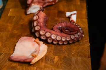 Close up of slicing boiled octopus tentacle with knife © Olesia Basova
