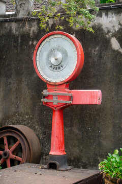 Sukoharjo, Indonesia, August 22, 2026 : Vintage Red Avery Mechanical Industrial Weighing Scale Outdoor.  An old vintage red Avery mechanical heavy duty weighing scale
