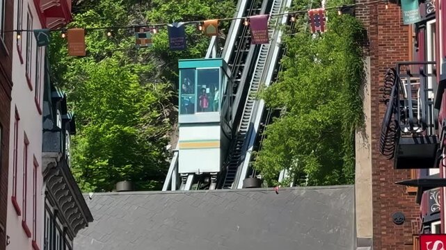The historic funicular ascends a cliff between old buildings in Quebec City, Quebec, Canada. 