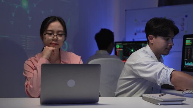 Asian software developers working late at night in tech office