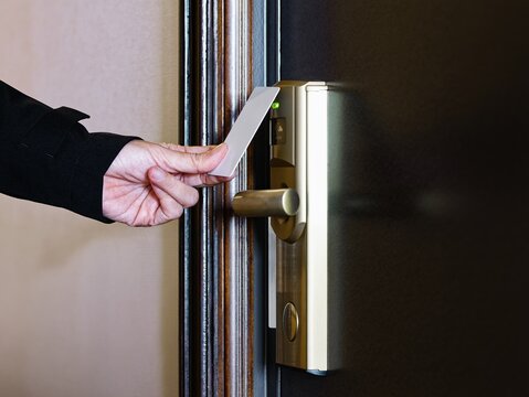 Hand with Key card access touch card Hotel door room Security system 