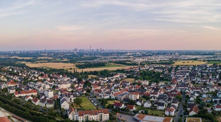 Luftaufnahme eines Frankfurter Vororts mit weit entfernter Skyline am Horizont bei Sonnenuntergang © saturn06