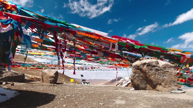 Low angle view of prayer flags and rocks beneath a blue sky