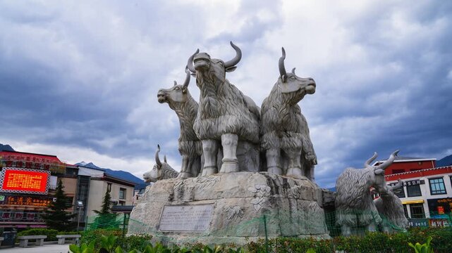 Stone yak sculpture group above a landscaped urban plaza