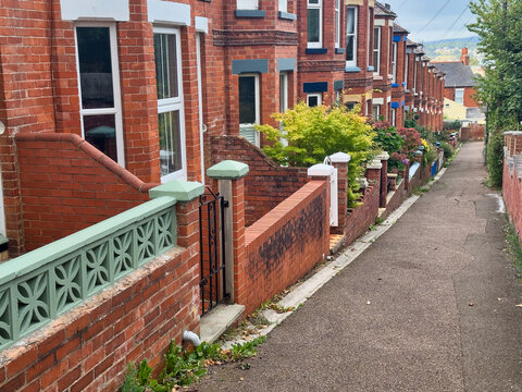 Traditional British Red Brick Terraced Houses and Narrow Alleyway with Front Gardens