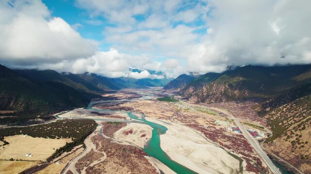 Braided turquoise river and pale floodplain in a Tibetan valley