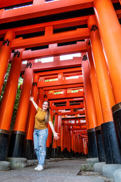 Turista mujer disfrutando su visita en Kioto, Japon, contemplando las puertas torii del santuario Fushimi Inari-taisha