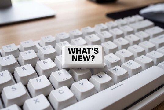 Close-up of white computer keyboard featuring a key with bold text WHAT'S NEW symbolizing updates and innovation