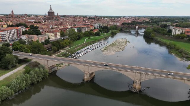 Europe, Italy, Pavia &ndash; drone views of the Ticino River, dried up due to drought and aridity - global warming and climate change in Ponte Coperto , Duomo cathedral and bridge with traffic car 