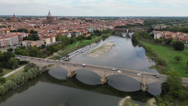 Europe, Italy, Pavia &ndash; drone views of the Ticino River, dried up due to drought and aridity - global warming and climate change in Ponte Coperto , Duomo cathedral and bridge with traffic car 