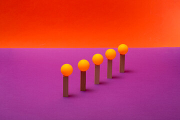 Five yellow spheres on wooden stands against a colored background © i_valentin