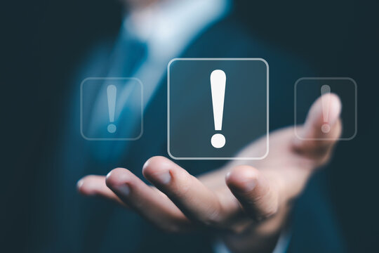 Exclamation mark warning alert symbol on a human hand representing business risk, safety, danger, emergency, cybersecurity, digital security, critical issues, protection, and risk management.