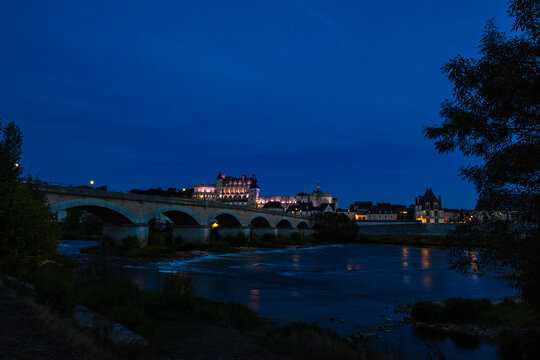 Amboise Royal Castle at dusk in the background of the Pont du Mar&eacute;chal Leclerc, seen from the banks of the Loire river