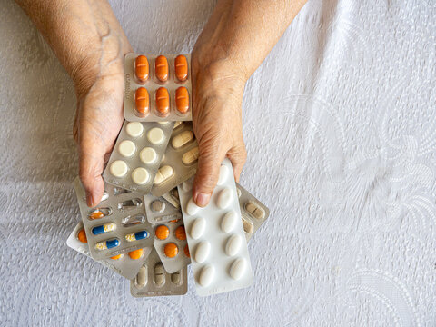 Senior Woman Hands Holding Multiple Medication Blister Packs at Home