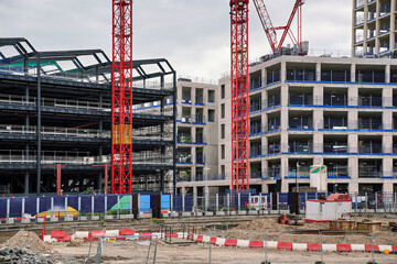 New large commercial or residential building construction site, empty concrete floors with scaffolding, industrial cranes around © Lubo Ivanko